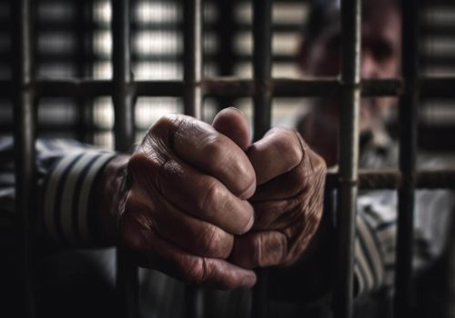 hands-man-holding-prison-cell-1.jpg